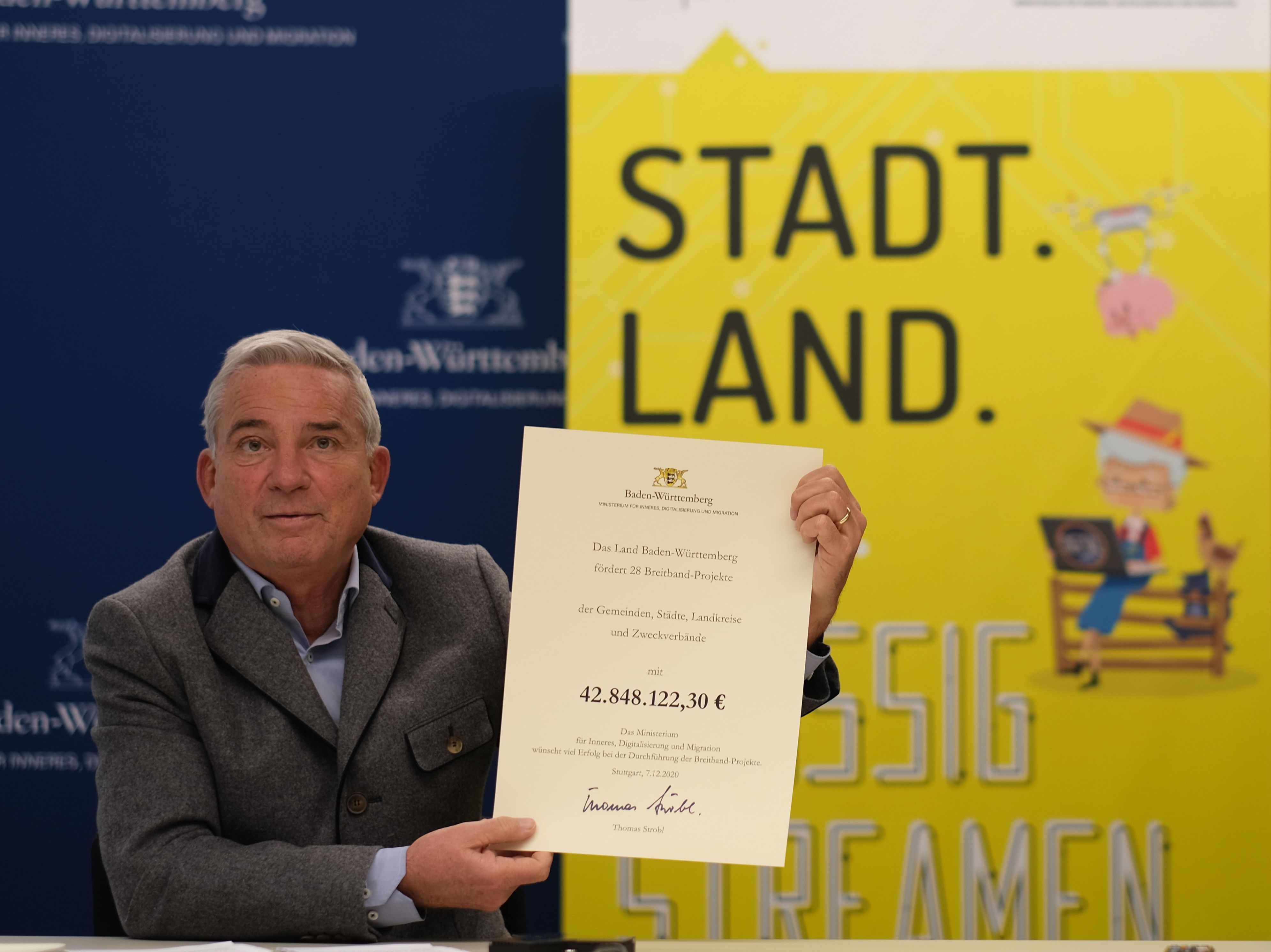  Minister Strobl hält den Breitbandförderbescheid in Händen 